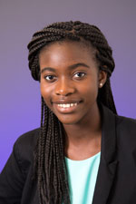 Smiling person with braided hair and blazer.
