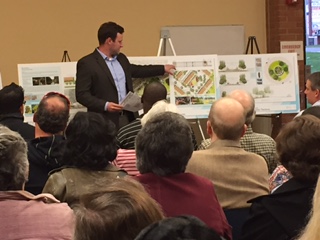 Man giving a presentation to an audience using visual aids.