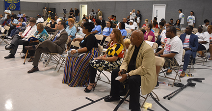 Audience attentively watching a presentation in a community hall.