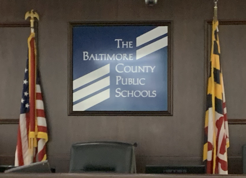 Sign for Baltimore County Public Schools with US and Maryland flags.