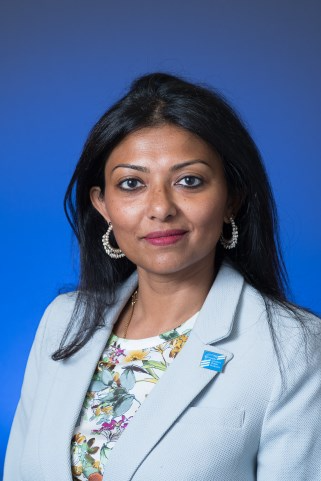 Family reunion group holding hands in a prayer circle outdoors.
