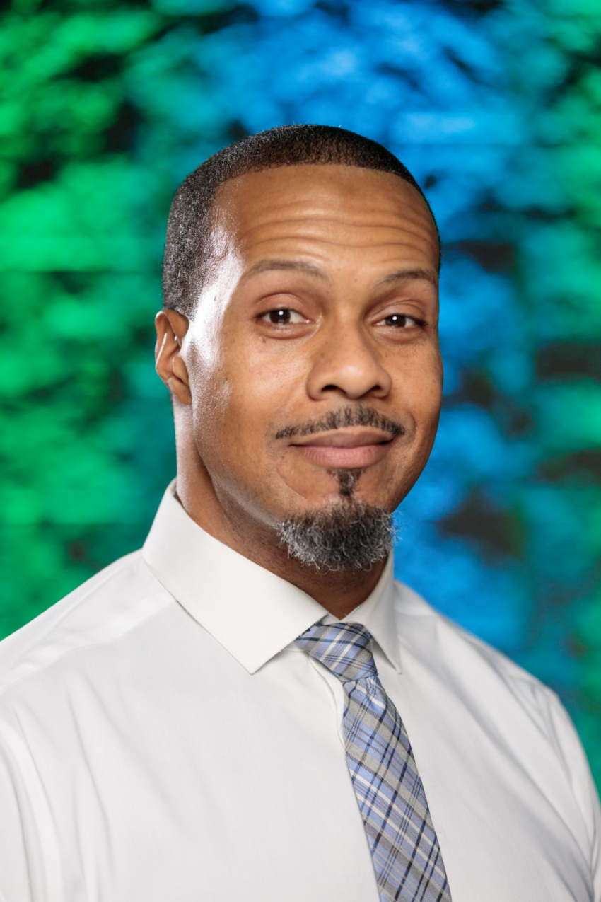 Man in white shirt and tie with colorful background.